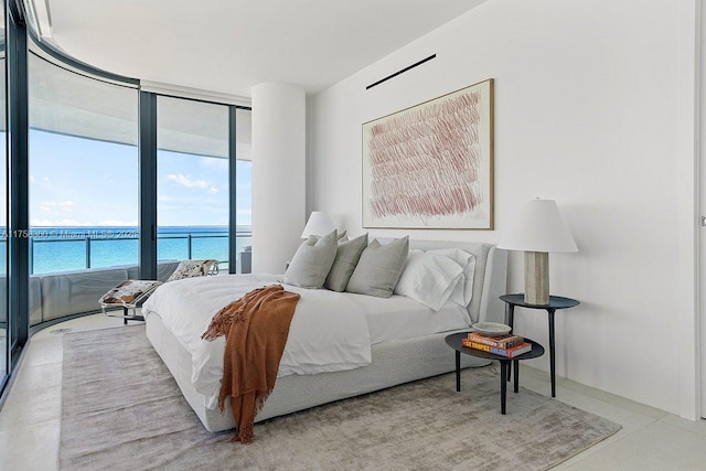 bedroom featuring a wall of windows, a water view, and access to outside