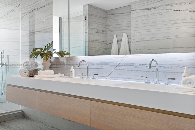 full bathroom featuring double vanity, tile walls, marble finish floor, and a marble finish shower