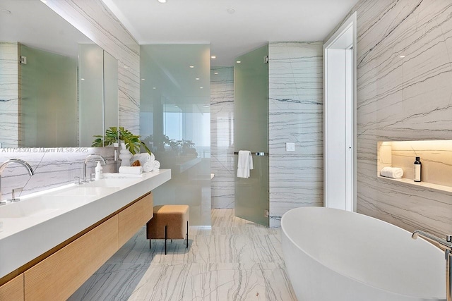 bathroom with a freestanding tub, marble finish floor, stone wall, and a walk in shower