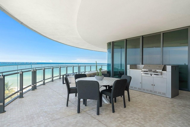 balcony featuring outdoor dining space, area for grilling, and a water view