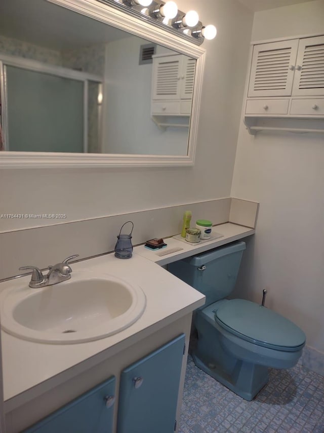 full bath with visible vents, toilet, a stall shower, and vanity