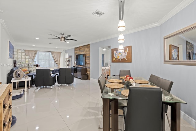 dining room featuring light tile patterned floors, a ceiling fan, visible vents, baseboards, and crown molding