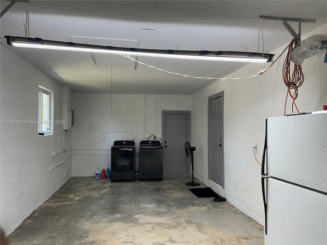 garage featuring freestanding refrigerator and washer and clothes dryer