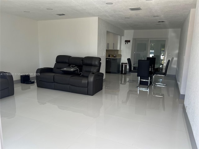 living area with visible vents and a textured ceiling