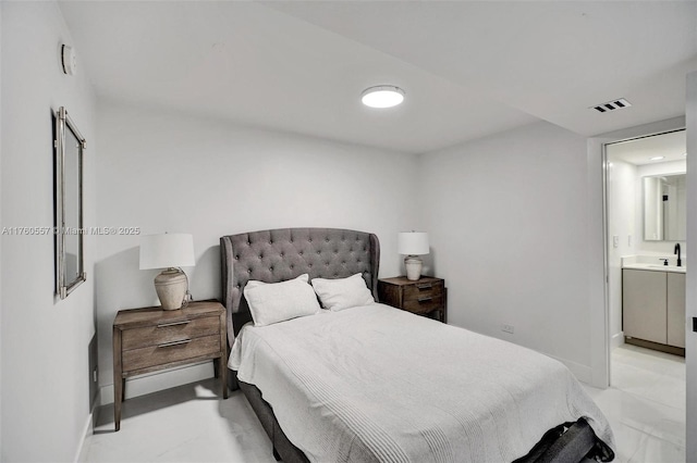 bedroom featuring visible vents, baseboards, and ensuite bath