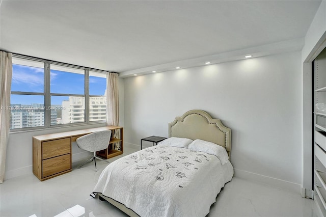 bedroom with a city view, recessed lighting, and baseboards