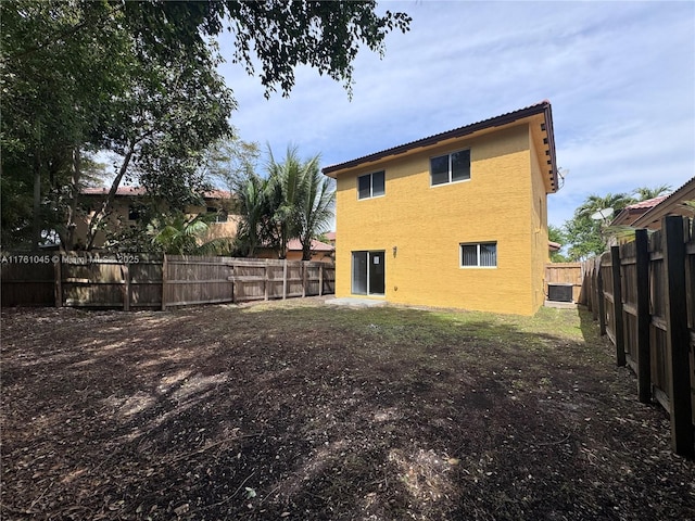 rear view of property featuring stucco siding and a fenced backyard