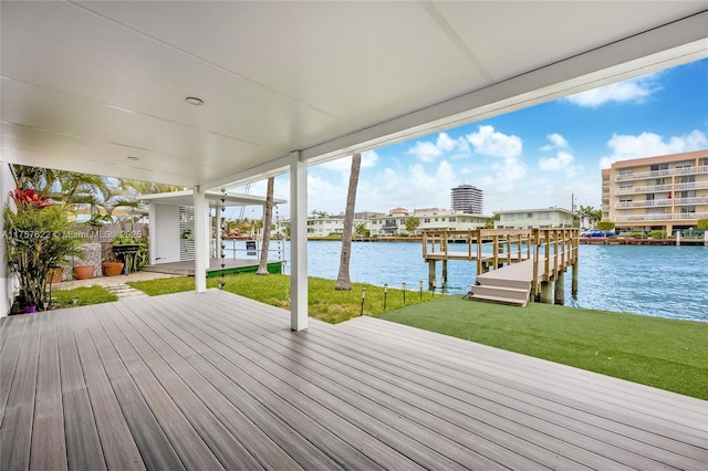 wooden terrace featuring a lawn, a boat dock, and a water view