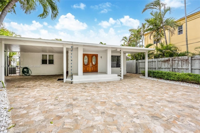 back of property with fence and stucco siding