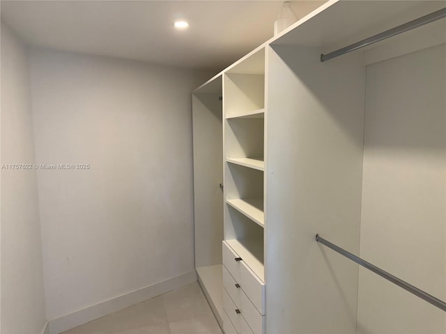 walk in closet with light tile patterned floors