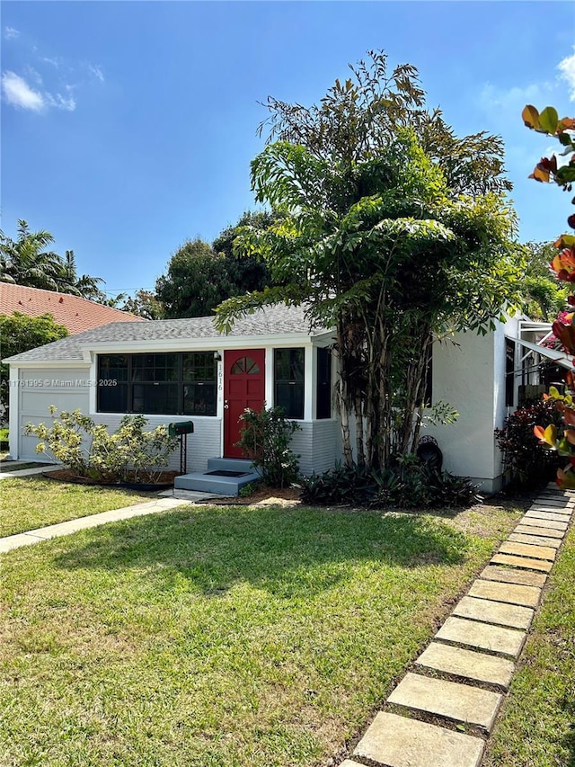 view of front facade featuring a garage, stucco siding, and a front lawn