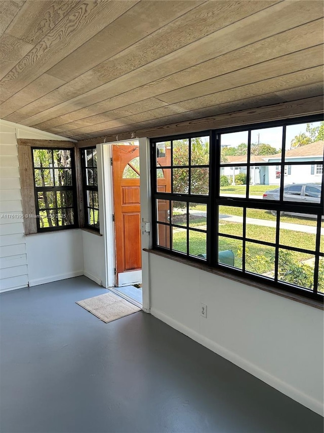 unfurnished sunroom with a wealth of natural light and wooden ceiling