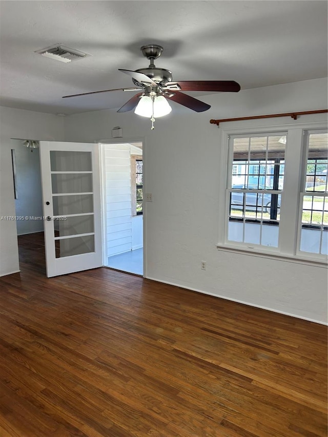 spare room featuring visible vents, wood finished floors, and a ceiling fan