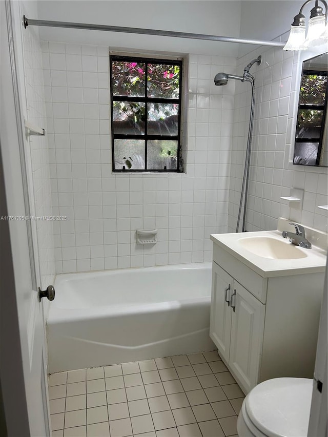 bathroom featuring tile patterned floors, toilet, a healthy amount of sunlight, and vanity