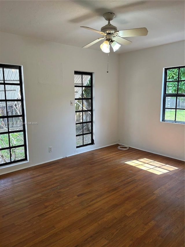 unfurnished room featuring ceiling fan, baseboards, and wood finished floors