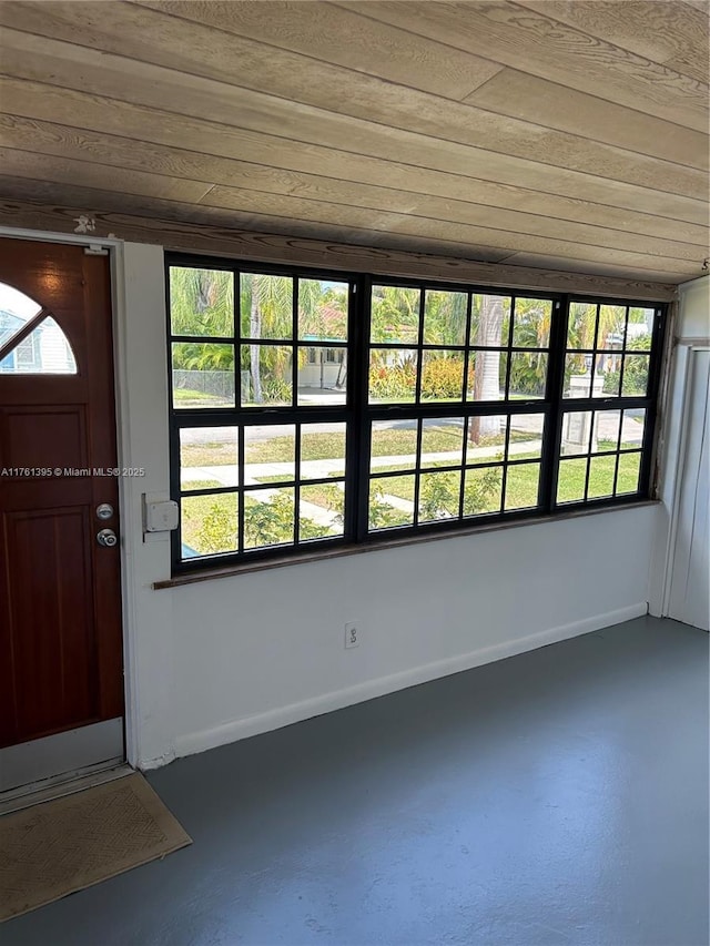 foyer with plenty of natural light, finished concrete flooring, and baseboards