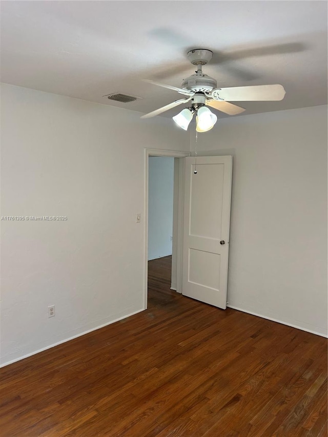 unfurnished room with visible vents, a ceiling fan, and wood finished floors