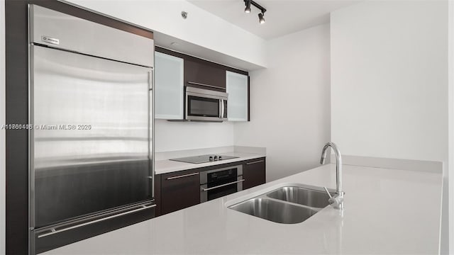 55 SE 6th St Unit 3701, Miami, FL 33131 - kitchen featuring a sink, stainless steel appliances, light countertops, rail lighting, and modern cabinets