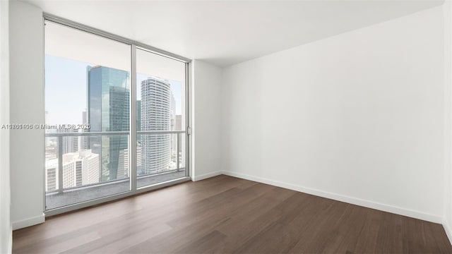 55 SE 6th St Unit 3701, Miami, FL 33131 - spare room featuring a city view, baseboards, and wood finished floors