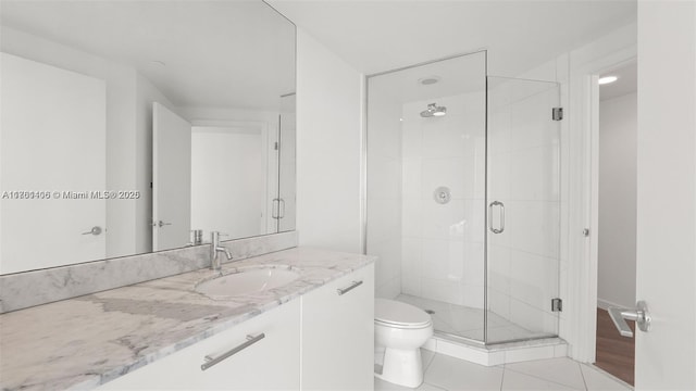55 SE 6th St Unit 3701, Miami, FL 33131 - bathroom with vanity, toilet, a shower stall, and tile patterned flooring