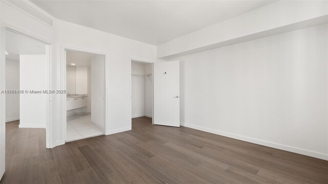 55 SE 6th St Unit 3701, Miami, FL 33131 - unfurnished bedroom featuring a closet, baseboards, and dark wood-style flooring