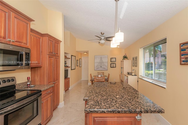 1154 SE 6th Ct, Dania Beach, FL 33004 - kitchen with ceiling fan, dark stone counters, brown cabinetry, and stainless steel appliances