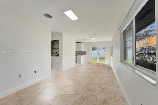 unfurnished room with light tile patterned floors, visible vents, and baseboards