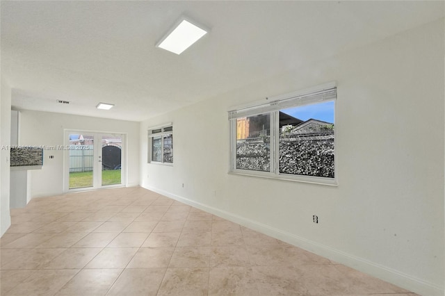 spare room with baseboards and tile patterned flooring