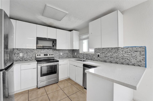 kitchen featuring tasteful backsplash, appliances with stainless steel finishes, light countertops, and a sink