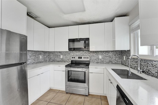 kitchen with a sink, decorative backsplash, appliances with stainless steel finishes, and white cabinets