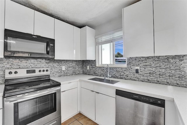 kitchen featuring a sink, stainless steel appliances, backsplash, and light countertops