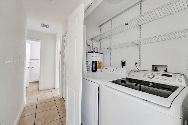 laundry room with light tile patterned floors, visible vents, laundry area, water heater, and washer and clothes dryer