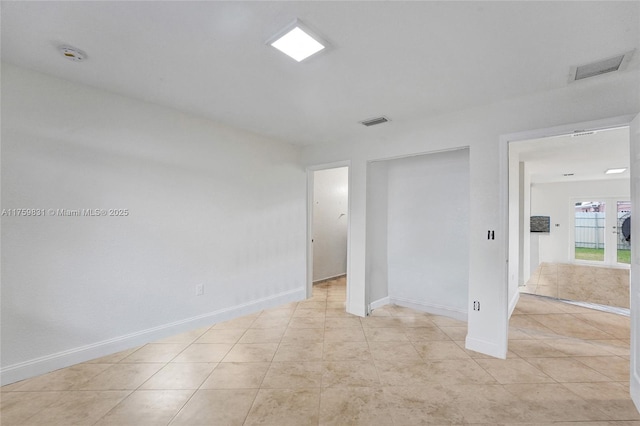 unfurnished bedroom featuring light tile patterned floors, baseboards, visible vents, and a closet