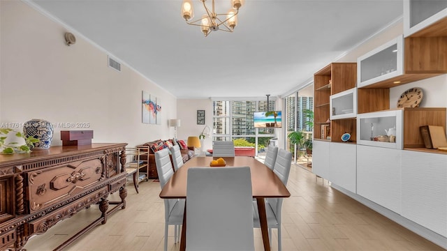 dining space featuring a chandelier, visible vents, floor to ceiling windows, and light wood-style flooring