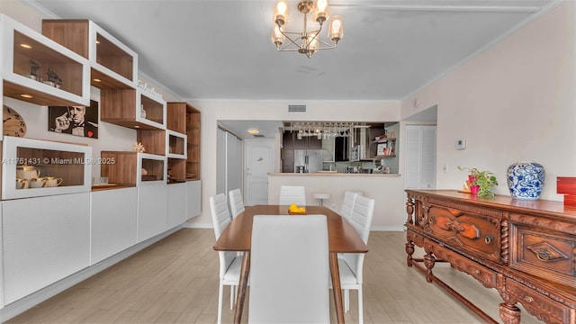 dining space with a chandelier, visible vents, light wood-type flooring, and crown molding