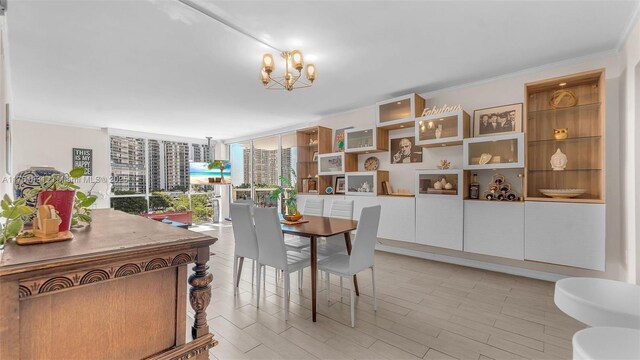 dining room with a wall of windows, a notable chandelier, light wood-style floors, and crown molding