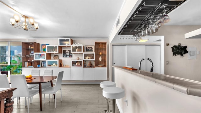 dining area featuring visible vents, an inviting chandelier, and wood tiled floor