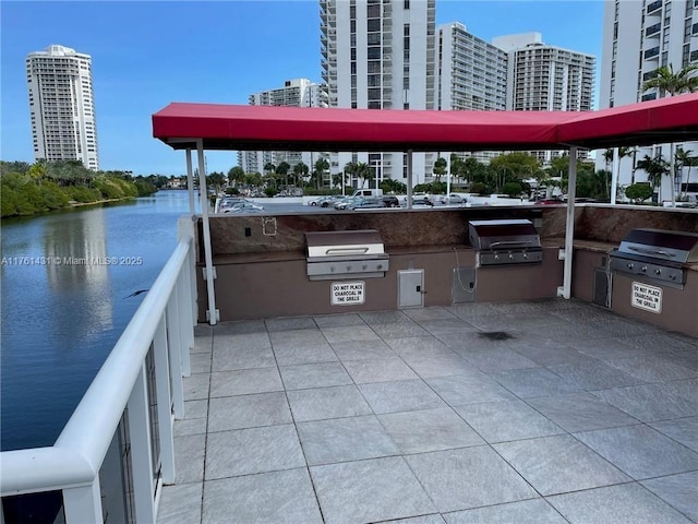 view of patio / terrace featuring a city view, a grill, and an outdoor kitchen