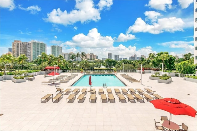 community pool with a city view and a patio