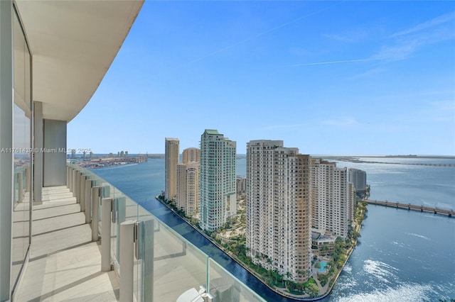 balcony with a water view and a view of city