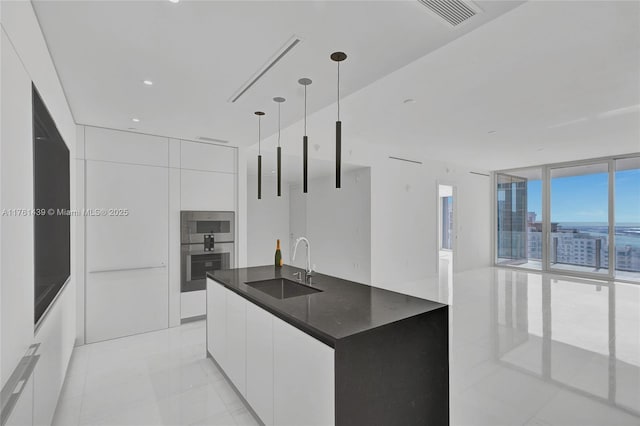 kitchen with expansive windows, modern cabinets, visible vents, and a sink