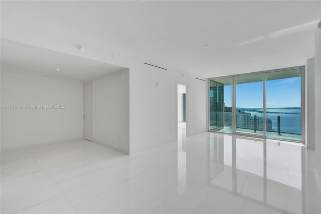 empty room with floor to ceiling windows and baseboards