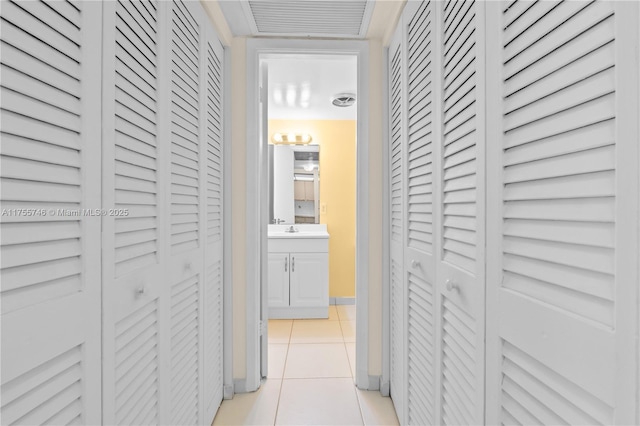 401 Golden Isles Dr Unit 516, Hallandale Beach, FL 33009 - corridor featuring light tile patterned floors and a sink