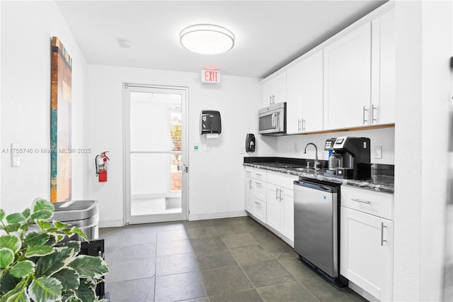 401 Golden Isles Dr Unit 516, Hallandale Beach, FL 33009 - kitchen with stainless steel microwave, refrigerator, white cabinetry, and dark stone counters