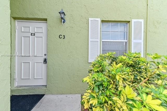 view of exterior entry with stucco siding