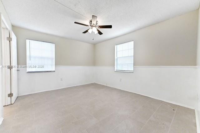 empty room with a textured ceiling and ceiling fan