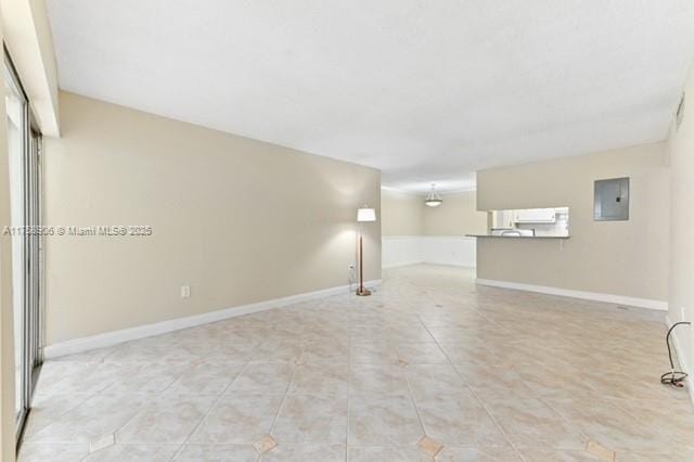 below grade area with electric panel, baseboards, and light tile patterned flooring