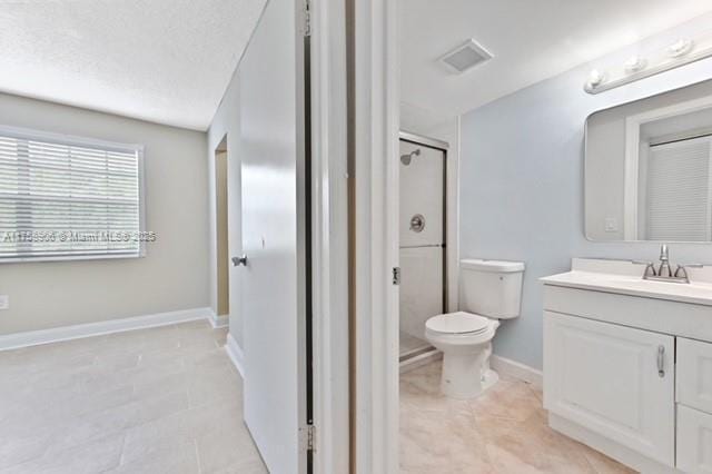 bathroom featuring vanity, baseboards, a stall shower, tile patterned floors, and toilet