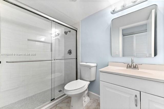 full bathroom featuring baseboards, toilet, a stall shower, and vanity