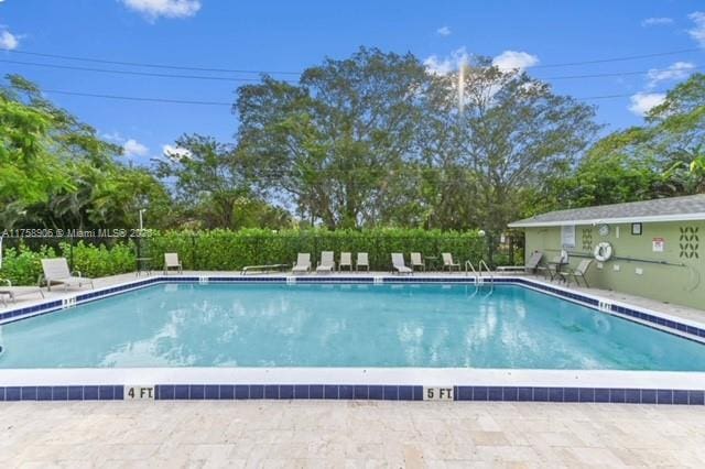 community pool featuring a patio area and fence